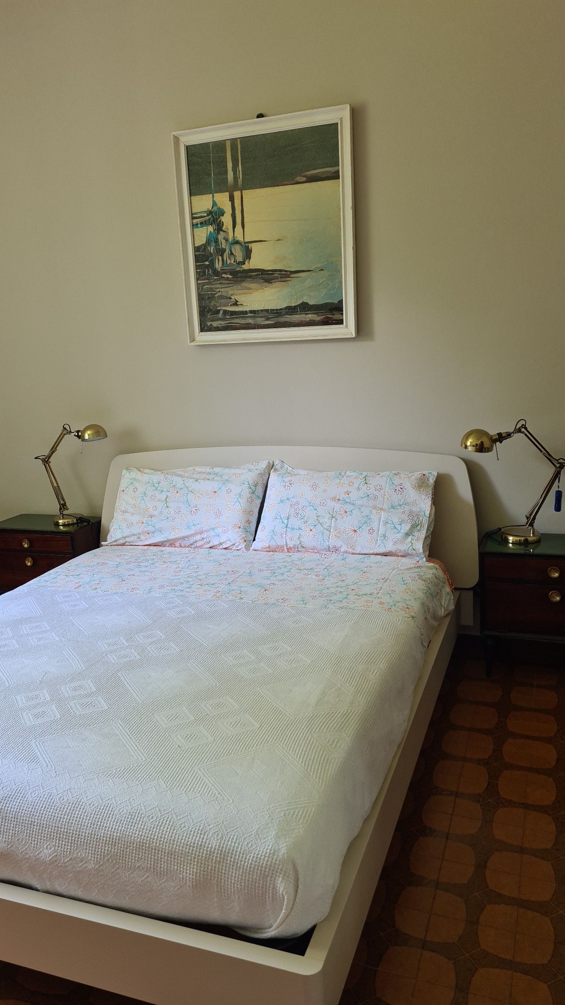 Actual Casa Luigi double bedroom with light patterned bed linen and white bedspread